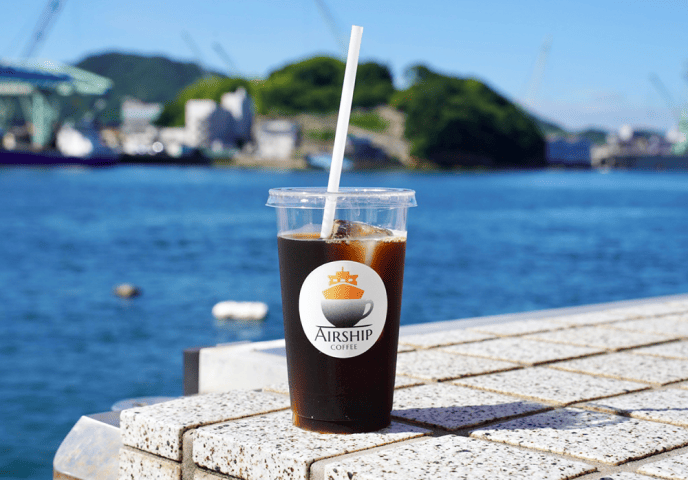 写真:海を背景にアイスコーヒー